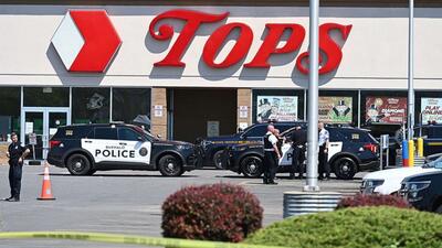 Police sit in front of a Tops Grocery store in Buffalo, N.Y., on May 15, 2022, after a white gunman fatally shot 10 people at a grocery store in a racially-motivated rampage, on May 14, 2022.