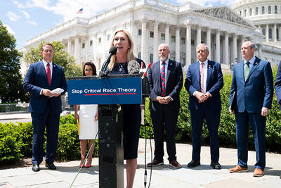 U.S. Rep. Marjorie Taylor Greene (R-Georgia) and other hard-line conservative members of Congress stand before the U.S. Supreme Court and the Capitol at an event denouncing critical race theory. 