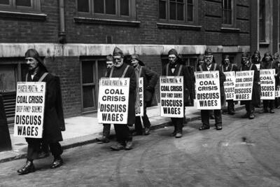 Coal heavers wear sandwich boards to protest against low wages in 1921.