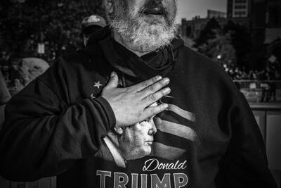 A man wearing a Donald Trump sweatshirt places his hand over his heart in the far-right group Super Happy Fun America protests in Boston on October 18. (Mark Peterson / Redux)